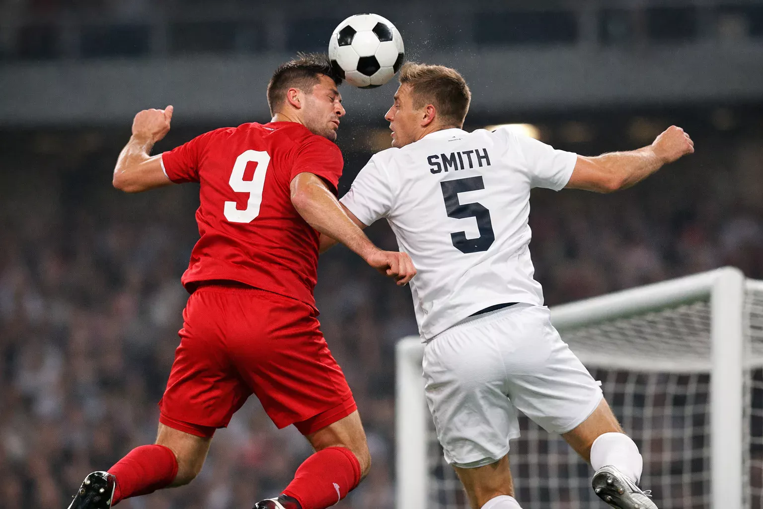 Aerial duel for a header from a corner kick, two players jumping to contest the ball in the penalty area