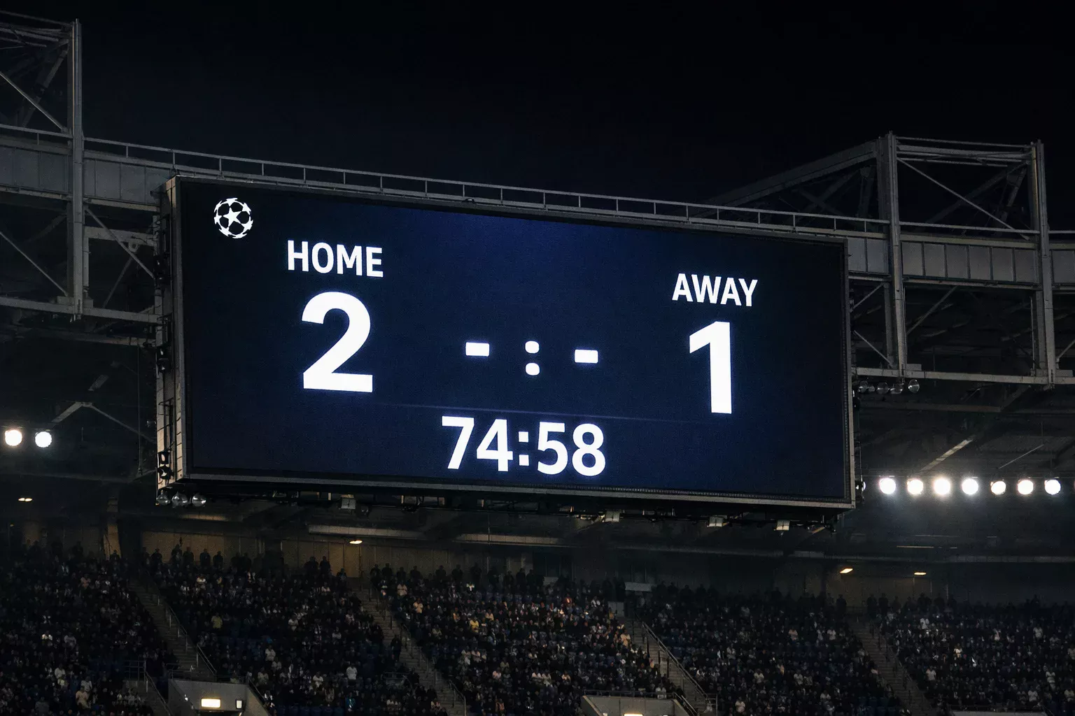 Stadium scoreboard displaying match information during a night football match