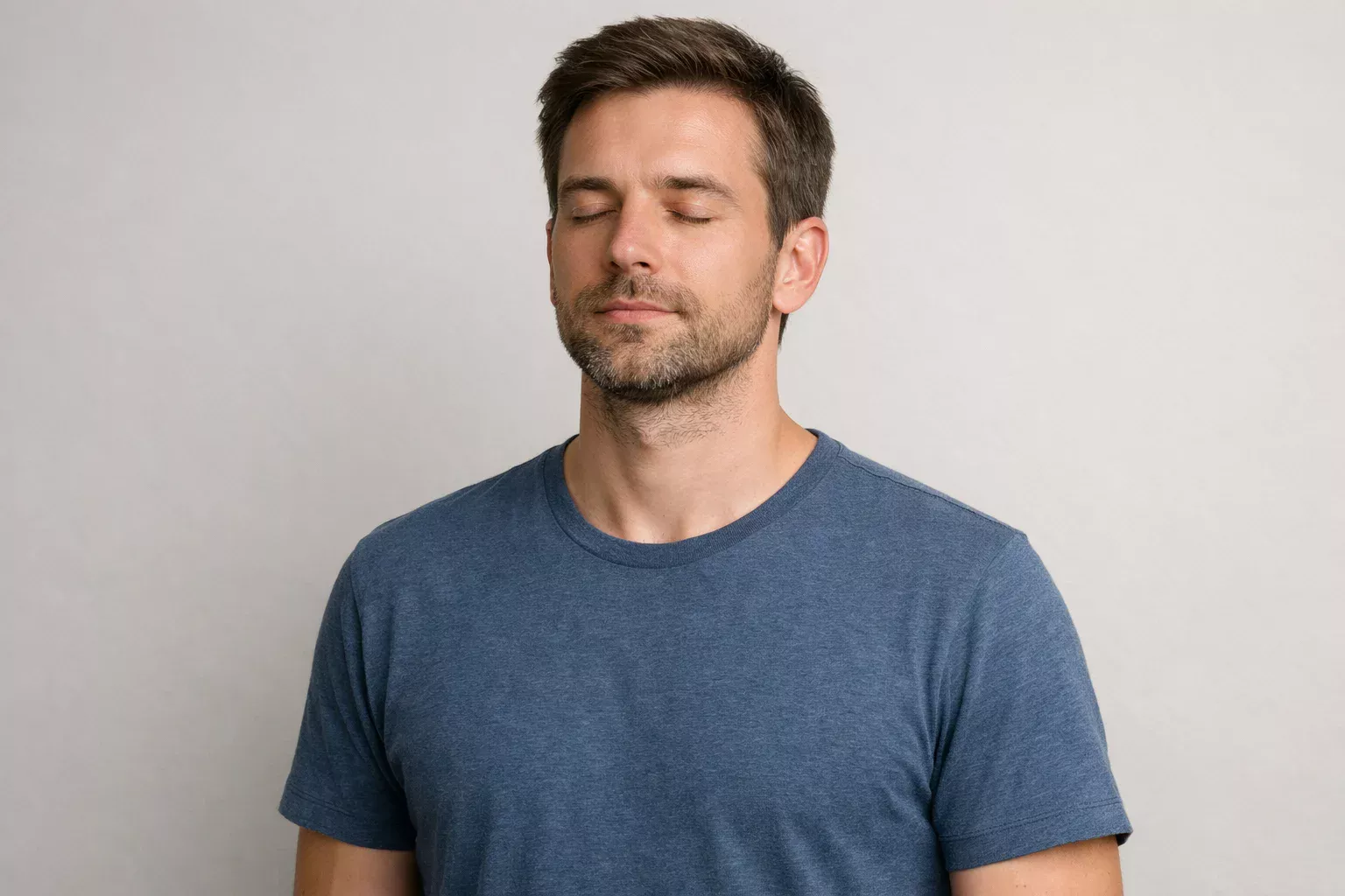 Person taking a deep breath with eyes closed, moment of calm and composure