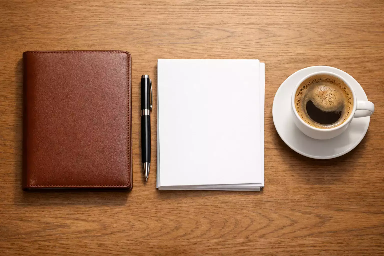 Desktop workspace with notebook, pen, and organized documents showing careful planning and organization